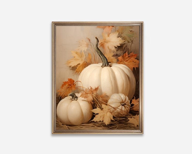 May include: A framed still life painting featuring three white pumpkins of varying sizes, surrounded by autumn leaves in shades of orange and yellow. The pumpkins are set against a neutral background, creating a warm, seasonal aesthetic.