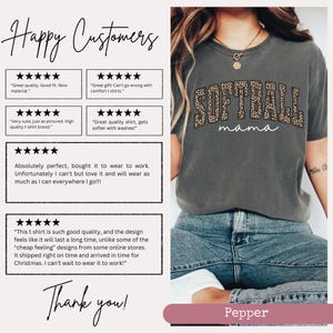 May include: A gray t-shirt with a leopard print design that says "Softball Mama" in white text. The shirt is being worn by a person with blue jeans. The image includes customer reviews and a thank you message.