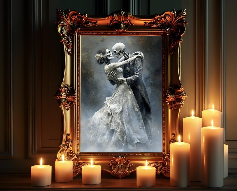May include: A framed artwork depicts a skeletal couple embracing in a romantic pose. The ornate gold frame surrounds the image, and several lit candles are placed in front of the artwork, creating a warm glow.
