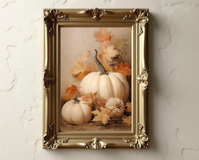 May include: A framed artwork featuring a still life of white pumpkins and autumn leaves. The pumpkins are arranged with fall foliage in a gold ornate frame. The artwork evokes a harvest theme.