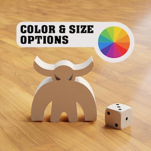 Puede incluir: Figurita de monstruo blanco con cuernos y un dado sobre una superficie de madera. El texto "COLOR & SIZE OPTIONS" está sobre el monstruo con una rueda de colores a la derecha.