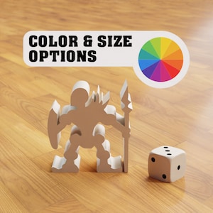 May include: A white plastic figurine of a warrior holding a spear and shield. The figurine is standing on a wooden surface. A white dice with black dots is next to the figurine. A white label with the text "COLOR & SIZE OPTIONS" is above the figurine. A color wheel is to the right of the label.