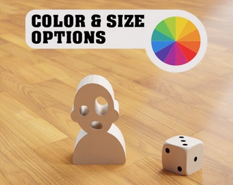May include: A white figurine of a person with a color wheel and a white die on a wooden surface. The text "COLOR & SIZE OPTIONS" is above the color wheel.