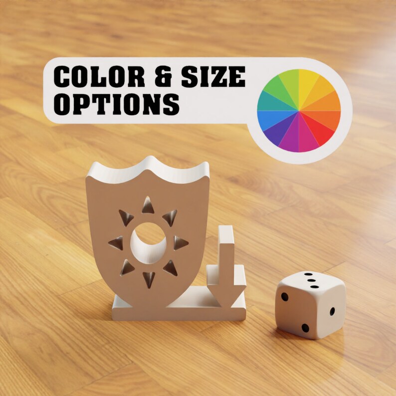 Puede incluir: Un escudo blanco con un dise&ntilde;o de sol y una flecha blanca apuntando hacia abajo. El escudo y la flecha est&aacute;n sobre una superficie de madera. Un dado blanco con puntos negros est&aacute; a la derecha del escudo y la flecha. El texto "COLOR & SIZE OPTIONS" est&aacute; encima del escudo y la flecha. Una rueda de colores est&aacute; a la derecha del texto.