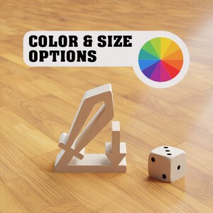 Peut inclure: Un support en forme d'épée et de flèche imprimé en 3D blanc avec un dé blanc sur une surface en bois. Le support est conçu pour tenir une épée et une flèche, et le dé est utilisé pour déterminer le résultat d'un jeu ou d'une activité. Le support est un excellent moyen d'afficher votre épée et votre flèche préférées, et le dé ajoute un élément amusant à tout jeu ou activité.