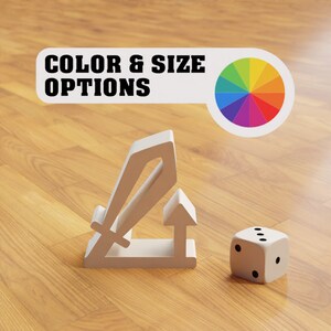 May include: A white plastic tabletop game piece shaped like a sword and shield. The piece is on a wooden surface next to a white die with black dots. The text "COLOR & SIZE OPTIONS" is visible in the background.