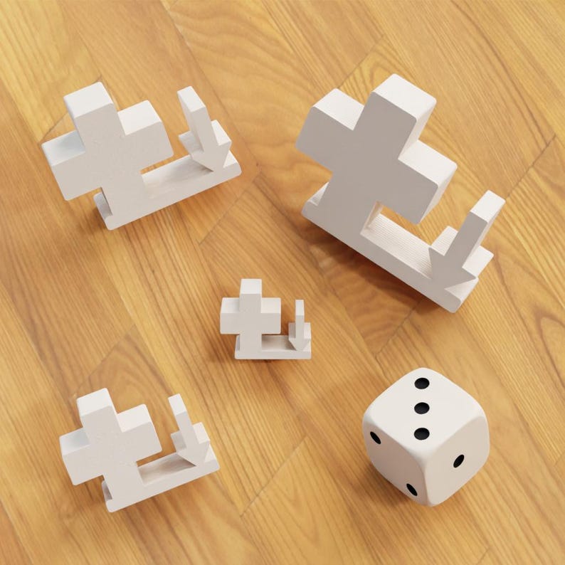 May include: A collection of white wooden puzzle pieces and a die on a wood grain surface. The puzzle pieces are cross-shaped with an arrow, and the die has black dots.