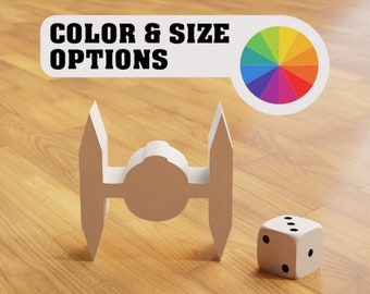 May include: A white TIE fighter model with a white die next to it. The text "COLOR & SIZE OPTIONS" is on a white banner above the model with a color wheel to the right of the text.