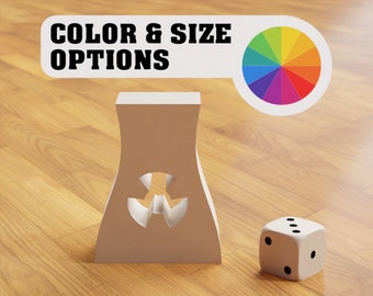 May include: A white, stylized nuclear power plant model with a cut-out design, next to a white die with three visible dots. The image includes a banner that reads "COLOR & SIZE OPTIONS" and a color wheel.