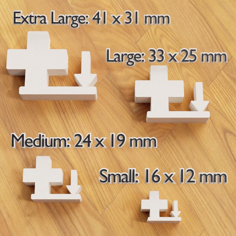 May include: Four white, cross-shaped wooden puzzle pieces of varying sizes, each with a downward-pointing arrow. Sizes are labeled: Extra Large (4.1 x 3.1 cm), Large (3.3 x 2.5 cm), Medium (2.4 x 1.9 cm), and Small (1.6 x 1.2 cm).