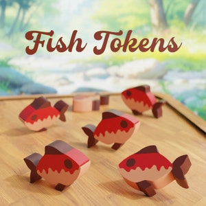 Könnte beinhalten: Fünf hölzerne Fisch-Spielmarken in Rot und Rosa mit einem wellenförmigen Muster. Die Spielmarken liegen auf einer Holzoberfläche. Der Text "Fish Tokens" ist in brauner Kursivschrift über den Spielmarken geschrieben.