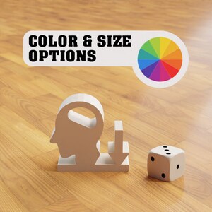 Può includere: Figurina bianca stampata in 3D di una testa con una freccia verso il basso, una ruota dei colori e un dado bianco con punti neri su una superficie di legno. Il testo "COLOR & SIZE OPTIONS" è su uno striscione bianco.