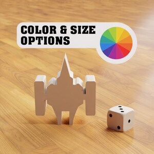 May include: A white spaceship-shaped toy with a colour wheel and a white die with black dots. The text "COLOR & SIZE OPTIONS" is on a white label.