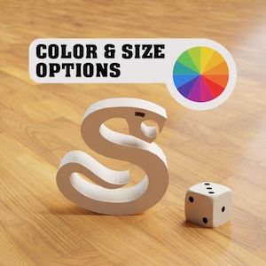 Könnte beinhalten: Weißer Holzbuchstabe S in Form einer Schlange, mit einem Farbkreis darüber und einem weißen Würfel mit schwarzen Punkten auf einem Holzboden. Der Text "COLOR & SIZE OPTIONS" befindet sich über dem Farbkreis.