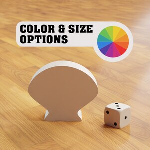Peut inclure: Un objet blanc en forme de coquille de mer avec une roue chromatique et le texte "COLOR & SIZE OPTIONS" au-dessus. Un dé blanc avec des points noirs est au premier plan.
