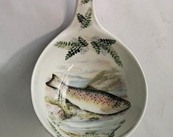 May include: White ceramic ladle with a green fern design on the handle and a painted image of a trout in a stream on the bowl. The bowl reads "The Willowood, The Sea Trout, 1994, Salmon & Sea Trout"