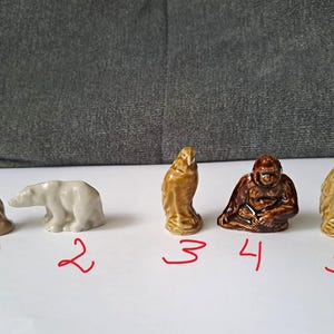 以下が含まれることがあります： フクロウ、ホッキョクグマ、ワシ、ゴリラ、別のワシなど、セラミック製の動物フィギュアのコレクション。フィギュアは茶色と白のさまざまな色合いで、詳細な特徴があります。各フィギュアの高さは約5〜7cmです。