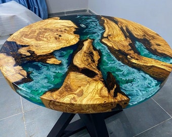 May include: Round wooden table top with a blue and green epoxy resin inlay. The resin has a swirling pattern and the wood has a natural grain.