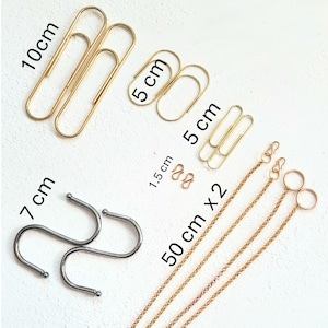 May include: An assortment of stationery supplies, including gold-colored paper clips in 10 cm and 5 cm sizes, small gold rings, and two 50 cm gold chains. Also included are silver-colored S-hooks, measuring 7 cm.