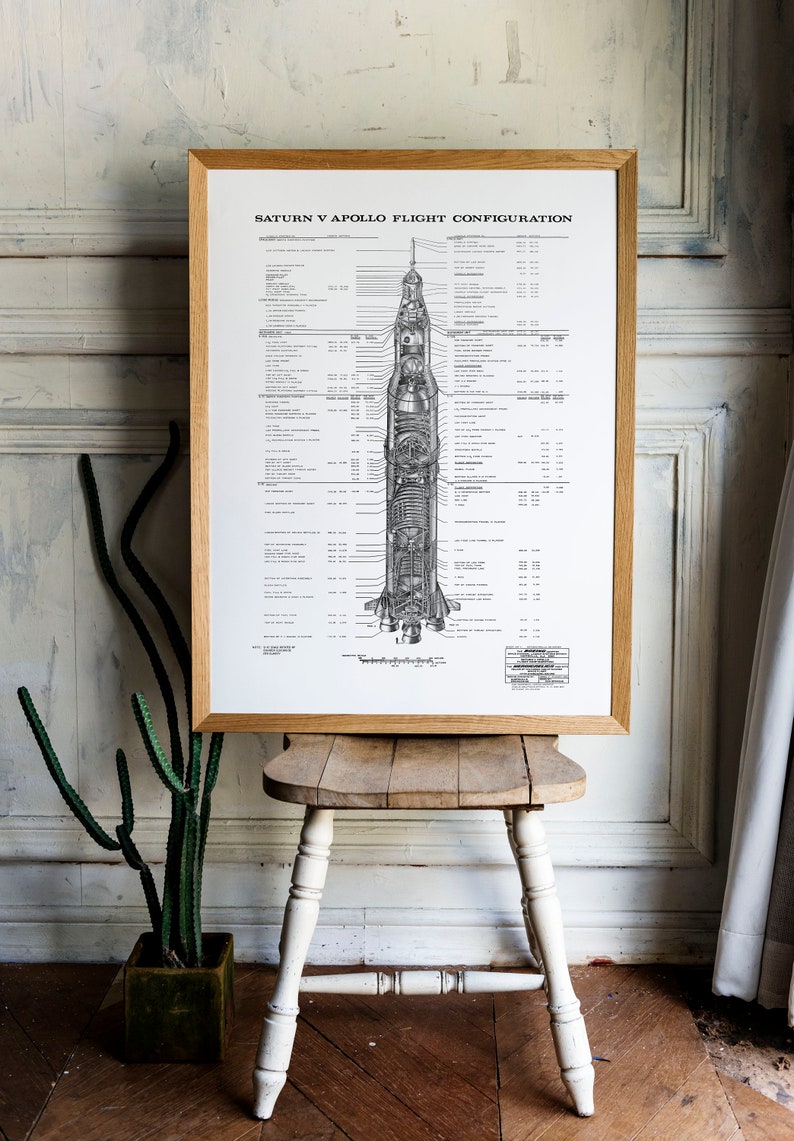 May include: A framed black and white diagram of the Saturn V Apollo flight configuration. The diagram shows the different stages of the rocket and the various components, including the command module, service module, and lunar module. The diagram is labeled with technical specifications and measurements.