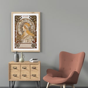 May include: A framed print of a vintage art nouveau poster featuring a woman with flowing hair and a crown of flowers. The poster is titled "La Plume" and is surrounded by a decorative border.