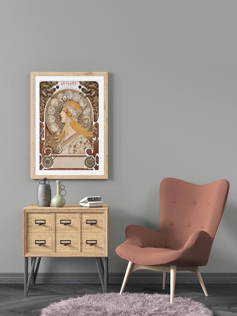 May include: A framed print of a vintage art nouveau poster featuring a woman with flowing hair and a crown of flowers. The poster is titled "La Plume" and is surrounded by a decorative border.