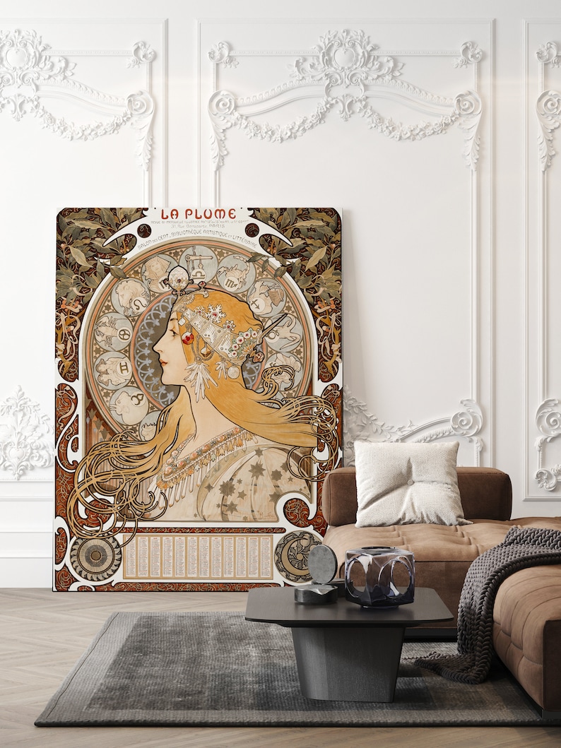 May include: A vintage art nouveau poster featuring a woman with flowing hair and a crown of flowers. The poster is titled "La Plume" and features a circular design with zodiac symbols. The poster is printed on a textured paper and has a brown and gold color scheme.