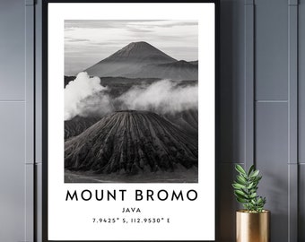 May include: Black and white photograph of Mount Bromo, a volcano in Java, Indonesia. The volcano is surrounded by clouds and mist. The text "MOUNT BROMO JAVA 7.9425° S, 112.9530° E" is printed below the image.