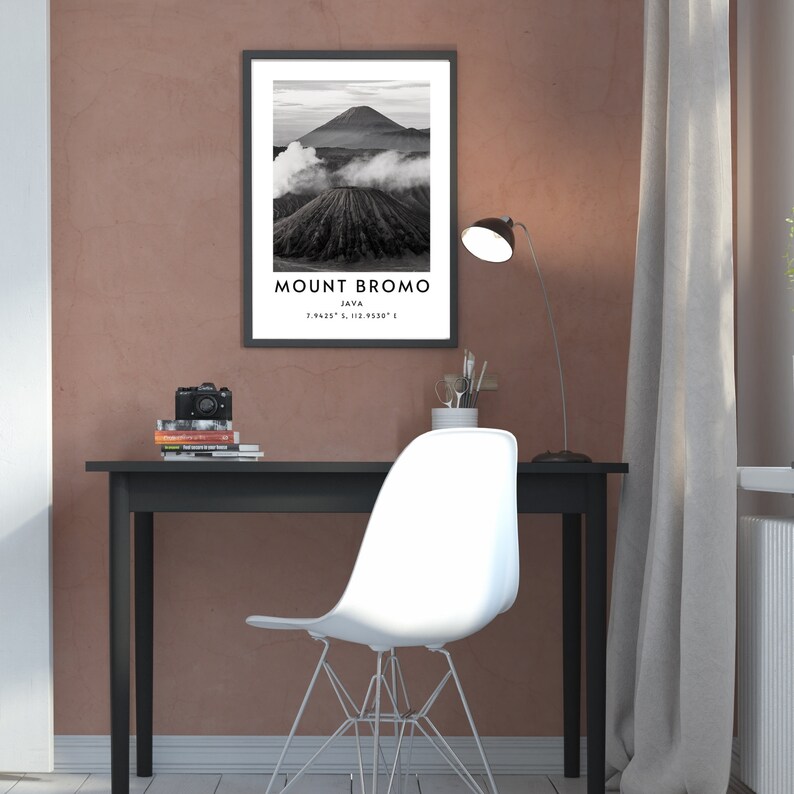 K&ouml;nnte beinhalten: Ein Schwarzwei&szlig;foto des Mount Bromo in Java, Indonesien. Das Foto ist gerahmt und h&auml;ngt an einer Wand &uuml;ber einem schwarzen Schreibtisch mit einem wei&szlig;en Stuhl. Der Text "MOUNT BROMO JAVA 7.9423&deg; S, 112.9330&deg; E" ist unter dem Bild gedruckt.