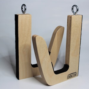 May include: Two wooden surfboard racks with a natural finish. Each rack has a U-shaped design with a black padded interior and a metal ring at the top for hanging. The brand name "BINDINGSINK" is visible on one rack.