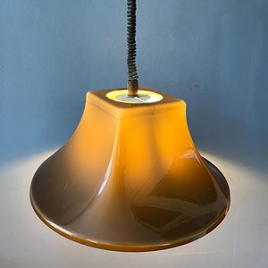 May include: A brown, bell-shaped pendant light with a black cord and a spring-like wire.