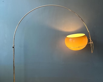 Puede incluir: Lámpara de pie de arco de estilo retro con acabado cromado y una pantalla esférica naranja. La lámpara tiene un brazo curvo que se extiende desde una base ovalada marrón. La pantalla emite un brillo cálido y acogedor.