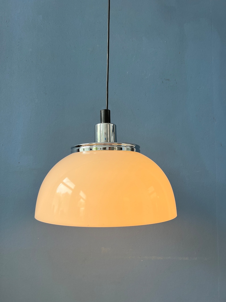 May include: A white dome-shaped pendant light fixture with a chrome finish and a black cord.