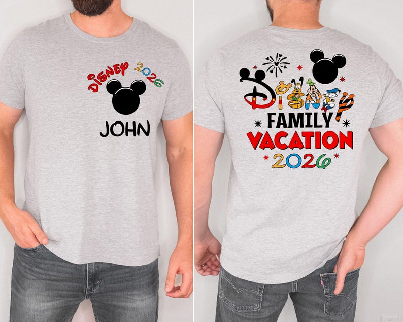May include: A light gray t-shirt with a colorful Disney design. The front of the shirt features the text "Disney 2026" above a black Mickey Mouse head and the name "JOHN". The back of the shirt has "Disney Family Vacation 2026" with character graphics.