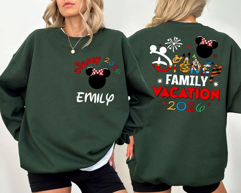 May include: Dark green sweatshirt with "Disney 2026" and a Minnie Mouse design on the front. The name "Emily" is below the design. The back features a "Family Vacation 2026" design with Disney characters and fireworks.