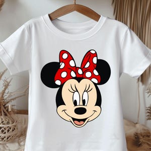 May include: White t-shirt with a red and white polka dot bow and a cartoon image of Minnie Mouse.