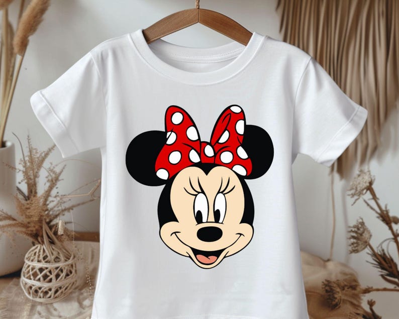 May include: White t-shirt with a red and white polka dot bow and a cartoon image of Minnie Mouse.