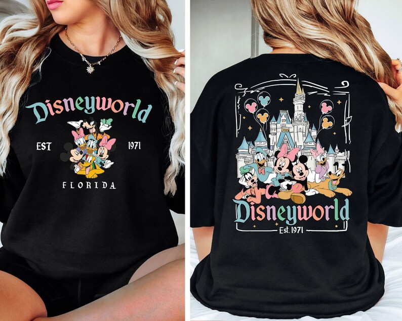 May include: Black long-sleeved top with a "Disneyworld" design in multiple colours on the front and back. The front graphic shows Mickey, Minnie, Donald, Daisy, and Goofy. The back graphic features the Disney castle and characters. "Est. 1971" is also displayed.