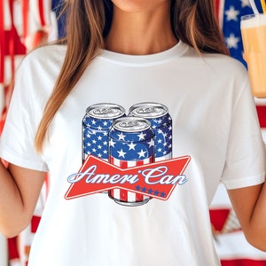 May include: White t-shirt with a graphic of three red, white, and blue beer cans with stars and stripes. The text "Ameri'Can" is printed in red with white stars.