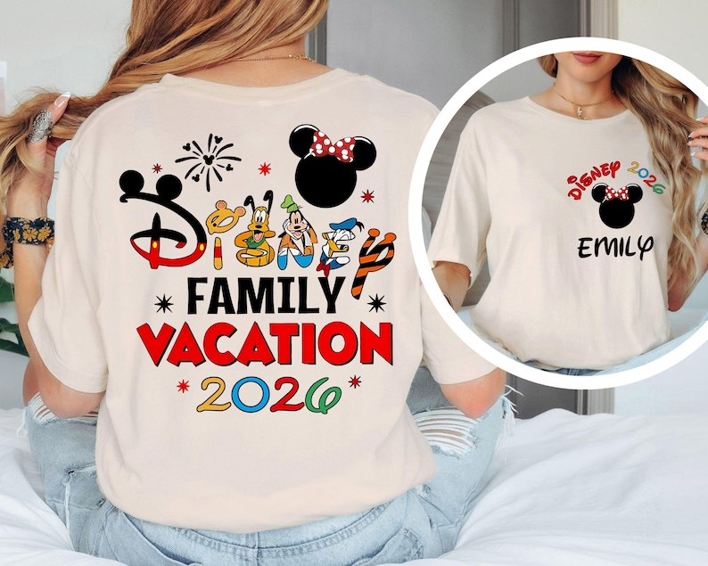 May include: Cream-colored t-shirt featuring a Disney-themed design. The back of the shirt displays the text "Disney Family Vacation 2026" with Mickey Mouse and friends. The front has a smaller design with "Disney 2026" and a name.