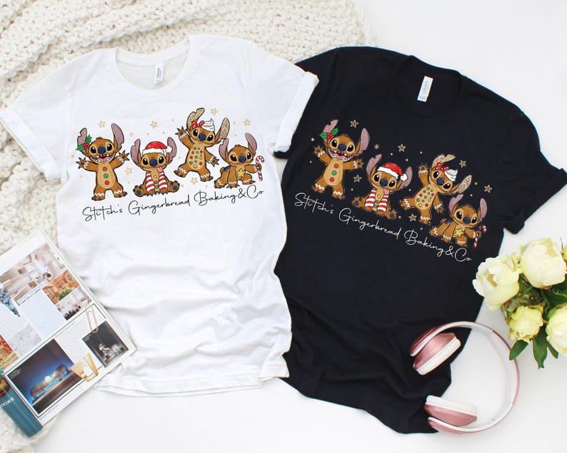 Puede incluir: Dos camisetas, una blanca y otra negra, cada una con un dise&ntilde;o de dibujos animados de personajes estilo pan de jengibre. Los personajes est&aacute;n decorados con accesorios tem&aacute;ticos navide&ntilde;os. El texto "Stitch's Gingerbread Baking & Co" est&aacute; impreso debajo.