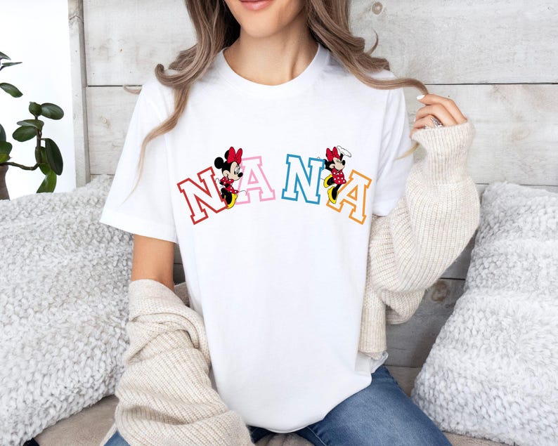 May include: White t-shirt with a colorful "NANA" graphic featuring Mickey Mouse characters.