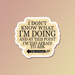 May include: A sticker with the text "I DON'T KNOW WHAT I'M DOING AND AT THIS POINT I'M TOO AFRAID TO ASK" in black font. The sticker has a beige background with a white border and an arrow pointing left with the words "To Be Continued".
