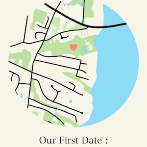 May include: A circular map print with a light beige background. The map features black roads, green park areas, and a blue body of water. A red heart marks a location. The text "Our First Date: 11/18/22" is below the map.