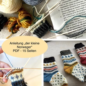 May include: Image of a knitting project with yarn, needles, and partially completed socks. The socks feature colorful patterns and designs. The image also includes a printed guide titled "Anleitung der kleine Norweger" (Instructions for the Little Norwegian).