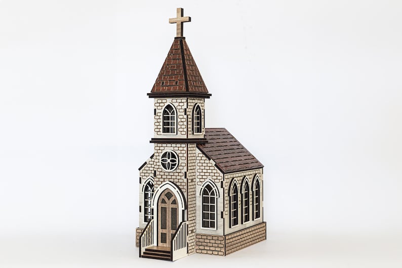 K&ouml;nnte beinhalten: Ein Holzmodell einer Kirche mit braunem Dach, wei&szlig;en W&auml;nden und schwarzen Fenstern. Die Kirche hat ein Kreuz auf dem Dach und eine kleine Veranda mit Stufen.