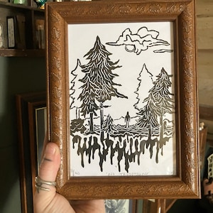 May include: A framed black and white print of a forest scene with a single figure standing in the middle. The print has a dripping effect at the bottom and the text "No Trespassing" is written below the image.