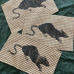 May include: Three black and white rat illustrations printed on brown and white gingham fabric.