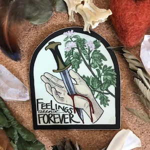 May include: A sticker with a hand holding a dagger through it, with a green plant growing around it. The sticker has a black border and the text "Feelings aren't forever" in black lettering.