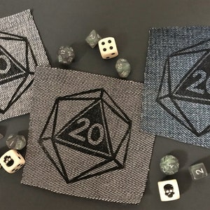 May include: Three denim patches with a black embroidered 20-sided die design. The patches are in different shades of blue and gray. There are also several black and white dice scattered around the patches.